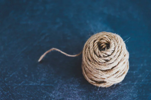 tangled ball of thread with string popping out of it