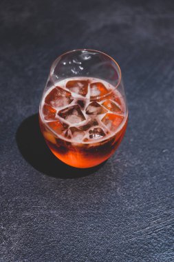 koyu beton üzerinde buz ile turuncu spritz kokteyl cam 
