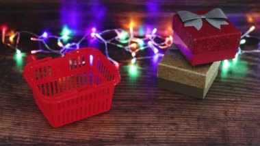 Peri ışıklarıyla çevrili Noel kutuları alışveriş sepetine taşınıyor.