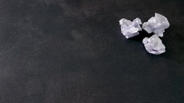 Yaratıcı blokçunun üstesinden gelen, kağıt kağıtlara kalem yerleştiren, buruşmuş kağıt toplarının yanına yerleştiren.