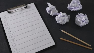 Üretkenlik eksikliğini aşan el, ampulü yapılacaklar listesine sıkıştırılmış kağıt toplarının yanına yerleştir