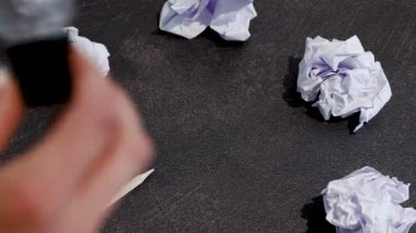 Kağıt topları, kalemleri ve aralarına el feneri yerleştirilmiş yaratıcı blok konsepti masası