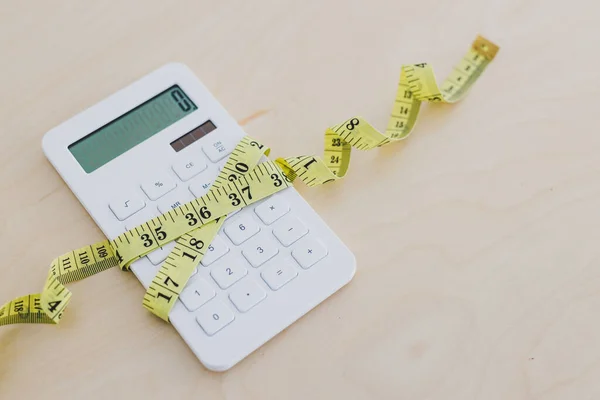 Увеличение бюджета, калькулятор, завернутый измерением крана — стоковое фото