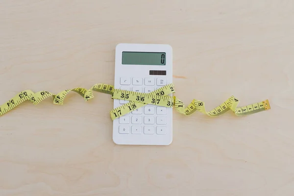 ightening up your budget, calculator wrapped up by measuring tap
