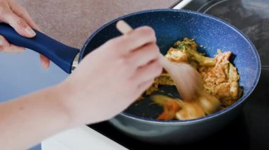 Ev yemeği konsepti. Kadın soteli sebzeli ve tofu kameralı Asya yemeği hazırlıyor.