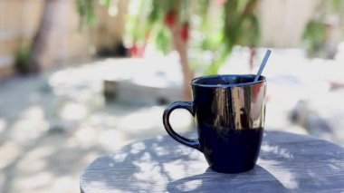 Kahve kültürü konsepti, arka planda bitki örtüsü olan açık kahve bahçesinde kahve tüttürme fincanı.