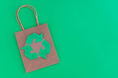 Üzerinde geri dönüşüm sembolü olan alışveriş çantası. Çevre dostu metafor. 