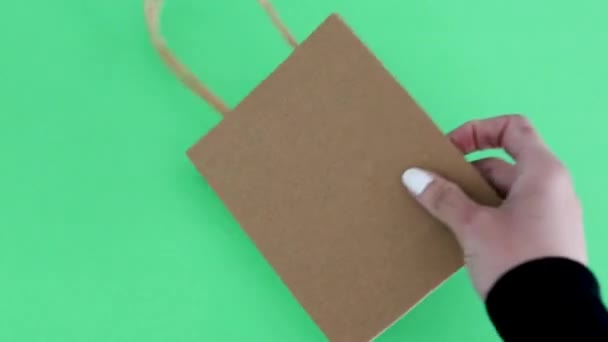 環境に優しい購買習慣の比喩をショッピングバッグの上にリサイクルシンボルを置く手 — ストック動画