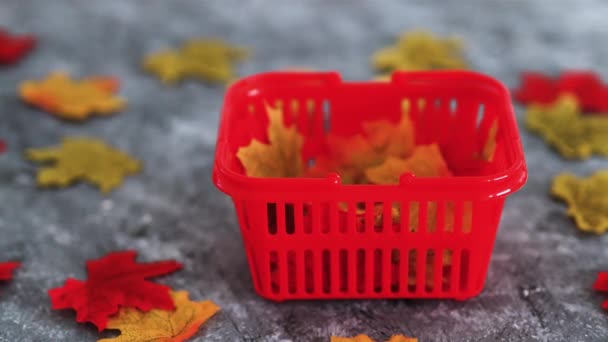 秋の商品と季節のショッピングコンセプト 緑黄色と赤のトーンとカメラのパンニングで紅葉とショッピングバスケット — ストック動画