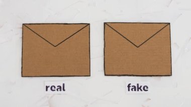 Güvenilir ve sahte e-postalar ya da çevrimiçi dolandırıcılık konsepti, e-posta zarfları, üzerinde gerçek ve sahte etiketler olan simgeler ve kameraların odaklanmasını bozan