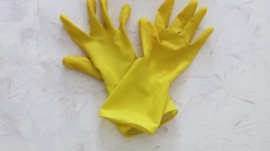 Bakteri ve virüslere karşı dezenfekte ve temizlik, beyaz yüzeyde sarı temizlik eldivenleri ve mikrofiber kumaş sterilize edilecek ve kamera dikey olarak çekilecek.