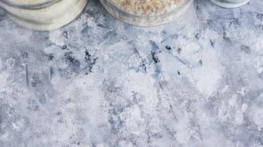 Vejetaryen kiler için sağlıklı bozulmaz gıda malzemeleri, yulaf unu, pirinç ve kamera ile dizilmiş cam kavanozlar dikey olarak