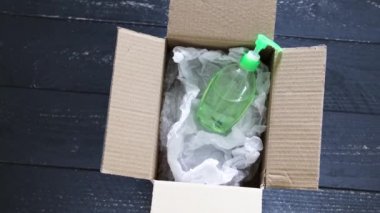 Virüs ve bakteri kavramına karşı hijyen, dağıtım paketinin içinde el dezenfektanı şişesi, kendinden izolasyon, karantina ve yatay tarama zamanlarında son derece aranan ürünler ve kamera sembolü.