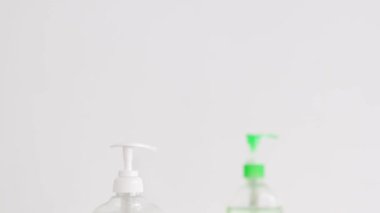 Hijyen ve bakterilerden korunma, el dezenfektanı ve mermer banyodaki sıvı sabun şişesi ve kamera dikey olarak çalışıyor.