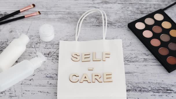 Self Care Botschaft Auf Einkaufstasche Umgeben Von Make Und Hautpflegeprodukten — Stockvideo