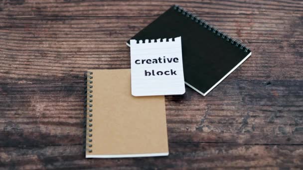 作家のブロック概念ビデオ ノートパッドと木製の机から創造的なブロックテキストで紙の部分を削除する手 — ストック動画