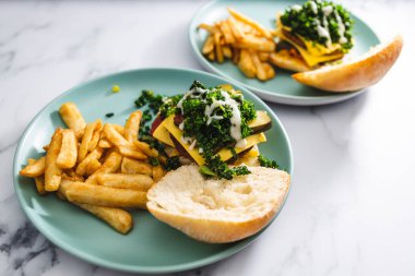 sağlıklı bitkisel yemek tarifleri konsepti, fasulyeli vejetaryen hamburgerler ve yanında patates kızartması ve sütsüz peynir.