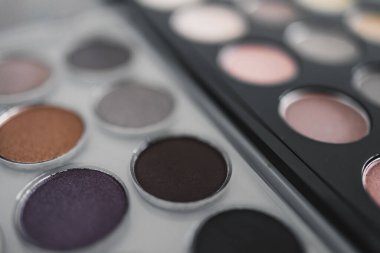 Kozmetik ve güzellik endüstrisi konsepti, iki benzer göz farı paletinin yan yana nötr çıplak tonlarıyla rekabet metaforu.