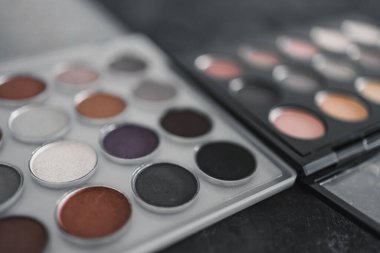 Kozmetik ve güzellik endüstrisi konsepti, iki benzer göz farı paletinin yan yana nötr çıplak tonlarıyla rekabet metaforu.