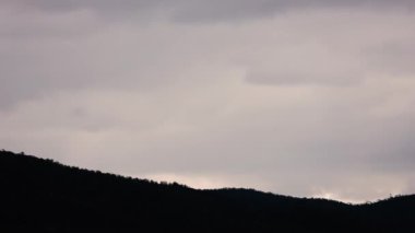 Tazmanya 'nın tepelerinde ve dağlarında hava değişiyor. Yoğun ışık ve güneş ışınları bulutların arasından yükseliyor.