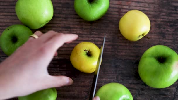 Hand Schneidet Apfel Zwei Hälften Auf Holztisch Neben Ganzen Äpfeln — Stockvideo