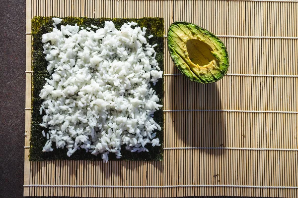 健康的な植物性食品レシピのコンセプト ビーガンアボカド寿司はローラーで調製取得 — ストック写真