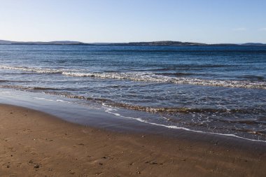 Güzel, el değmemiş Tazmanina plajı, sakin mavi gökyüzü, bir kış sabahı.