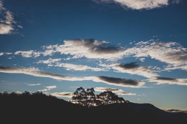 Günbatımı gökyüzü Tazmanya, Avustralya tepelerinde yuvarlanan güzel bulutlarla