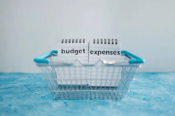 管理货币和财务概念 预算和支出笔记在蓝色桌子上的购物篮里并排排列 — 图库照片