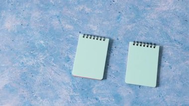 iş organizasyonu ve planlama konsepti, mavi arkaplan ve kamera paneli üzerinde eşleşen bir çift mavi not defteri