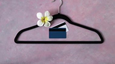 Moda endüstrisi konsepti, kadife kıyafetler pembe masada asılı çiçek ve büyüteç ve kamera eğimli.