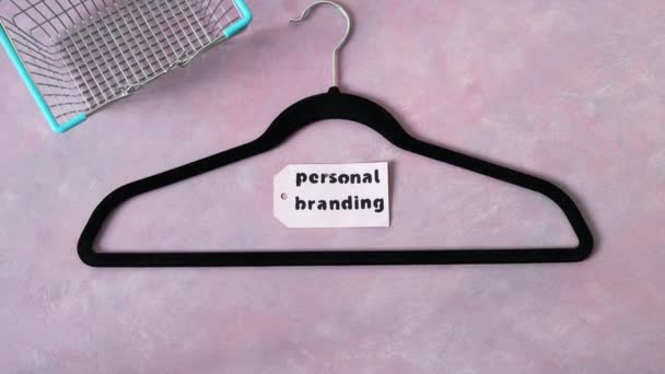 时尚与时尚行业理念 粉色桌子上的天鹅绒衣架 配有购物车 个人品牌标签和相机倾斜 — 图库视频影像