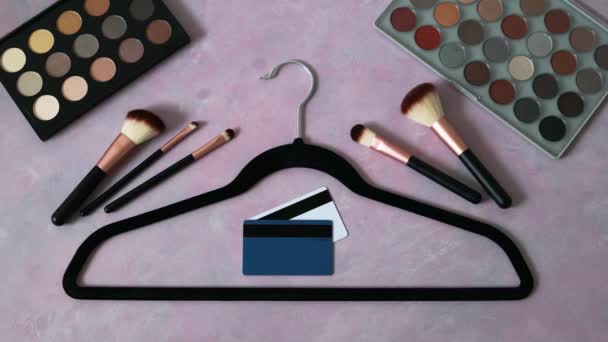 时尚购物理念 粉红桌子 上有化妆品和时尚饰品 包括衣架和手持信用卡 — 图库视频影像