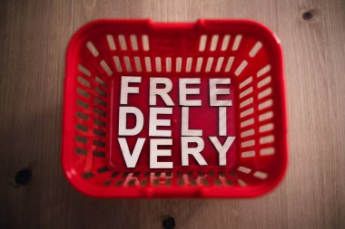 Çevrimiçi alışverişler ve temas yok, içinde ücretsiz teslimat metni olan alışveriş sepeti.