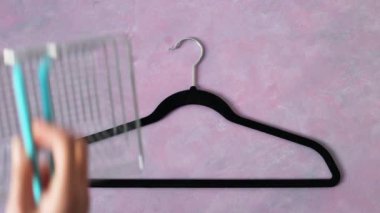 Moda endüstrisi konsepti, kadife elbise askısı pembe masa üzerinde el arabası ve kişisel marka etiketi.