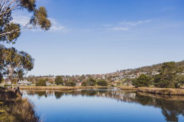 HOBART, TASMANIA - June 8th, 2020: beautiful Tasmanian landscape along the Browns River in Kingston Beach, a popular suburb south of Hobart featuring a golf course in the distance clipart