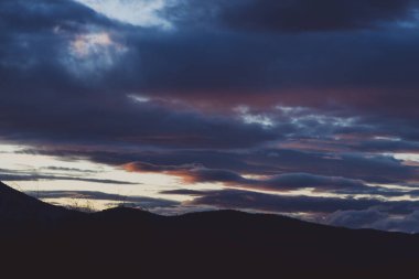 Günbatımı gökyüzü Tazmanya, Avustralya tepelerinde yuvarlanan güzel bulutlarla