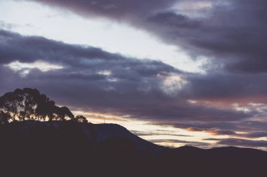 Günbatımı gökyüzü Tazmanya, Avustralya tepelerinde yuvarlanan güzel bulutlarla