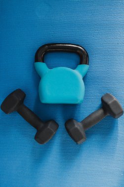 Sağlıklı ve sağlıklı yaşam tarzı konsepti, yoga minderinde ev aletleri, halterler ve kettlebell de dahil.