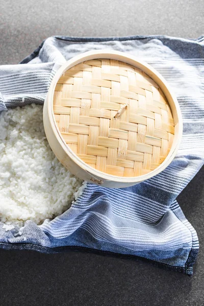 simple food ingredients concept, sticky sushi rice in traditional asian bamboo steamer