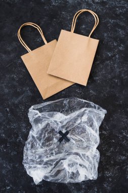 Ekolojik tercihler ve çevresel farkındalık kavramı plastik poşetin yanındaki kağıt torbalarda Sürdürülebilir Ürünler etiketi
