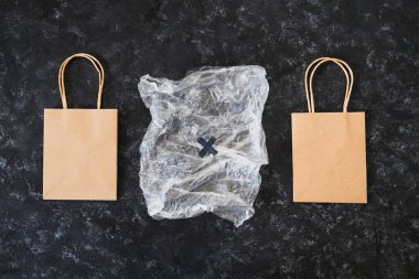 Ekolojik tercihler ve çevresel farkındalık kavramı plastik poşetin yanındaki kağıt torbalarda Sürdürülebilir Ürünler etiketi