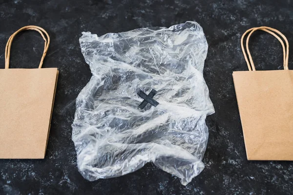 Ekolojik tercihler ve çevresel farkındalık kavramı plastik poşetin yanındaki kağıt torbalarda Sürdürülebilir Ürünler etiketi
