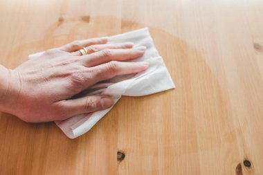 Bakteri ve virüslerin yüzeylerini dezenfekte etmek, ahşap sehpanın elle temizlenmesi, dezenfektan ıslak mendille dezenfekte etmek, covid-19 'dan sonra yeni normal konsepti.