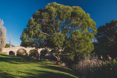 RICHMOND, 17 Temmuz 2020: Güneşli bir kış gününde Tazmanya 'daki Richmond Köprüsü' nde insanların tarihi yapıyı ziyaret etmesinin keyfini çıkardıkları tarihi eser listesindeki köprü.