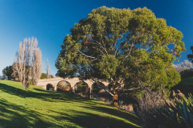 RICHMOND, 17 Temmuz 2020: Güneşli bir kış gününde Tazmanya 'daki Richmond Köprüsü' nde insanların tarihi yapıyı ziyaret etmesinin keyfini çıkardıkları tarihi eser listesindeki köprü.