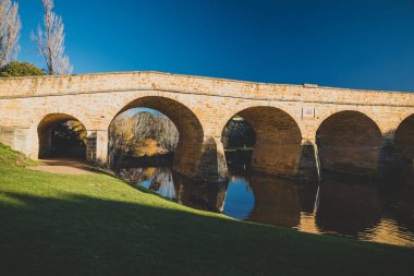 RICHMOND, 17 Temmuz 2020: Güneşli bir kış gününde Tazmanya 'daki Richmond Köprüsü' nde insanların tarihi yapıyı ziyaret etmesinin keyfini çıkardıkları tarihi eser listesindeki köprü.