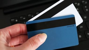 Çevrimiçi alışveriş veya internet bankacılığı kavramı, arka planda odaklanmamış dizüstü bilgisayarlı ödeme kartları