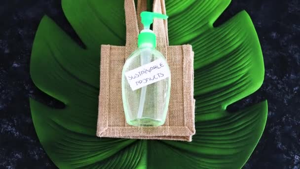 生態学的選択と環境意識の概念 再利用可能な袋と暗い背景とカメラの傾きの熱帯の葉で洗浄製品の持続可能な製品ラベル — ストック動画