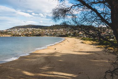 HOBART, TASMANIA - 1 Ağustos 2020: Güneşli bir kış gününde Blackmans Körfezi plajı, plajda çok az kişi varken, bölge Güney Hobart 'ın varlıklı bir banliyösüdür.